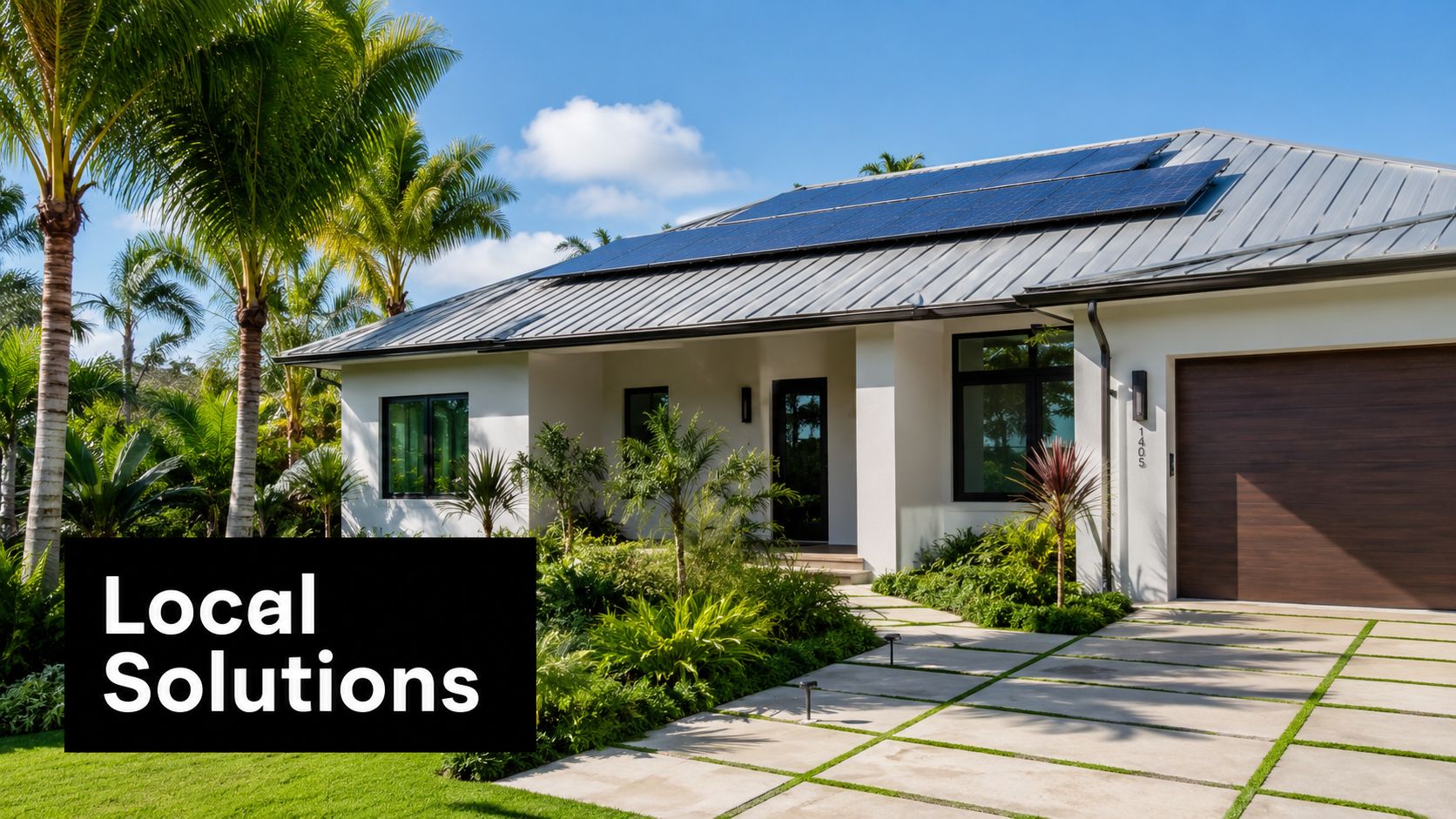 A modern single-story house with solar panels on the roof surrounded by lush green tropical plants.